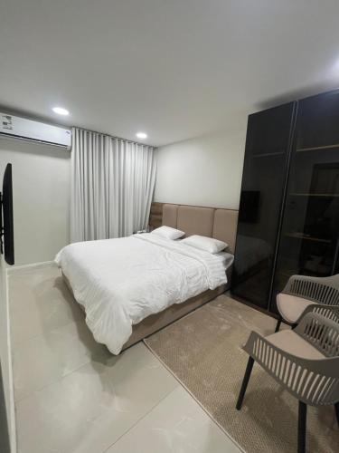 a bedroom with a white bed and a chair at سويتات الباديه in Dammam