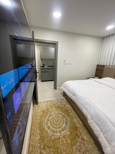 a bedroom with a large bed and a kitchen at سويتات الباديه in Dammam