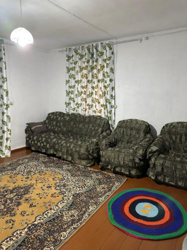 a living room with two couches and a rug at Vintage House Aisha in Kaji-Say