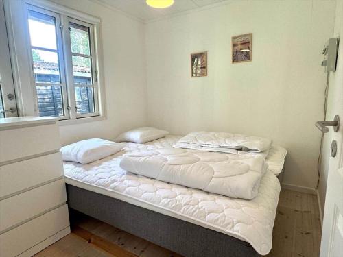 a bedroom with two beds with white sheets and a window at M27-Vaeggerlose-Tornbladvej-14 in Bøtø By