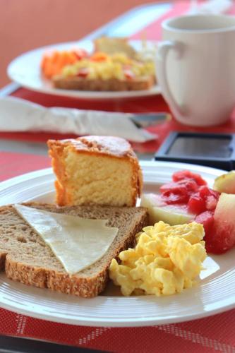 a white plate with breakfast foods on a table at Hostal Santa Barbara in Santo Domingo