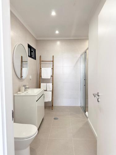a bathroom with a toilet and a sink and a mirror at Waves Madeira II in Caniçal