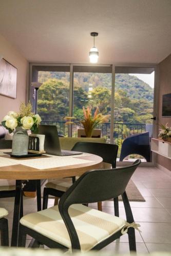 a restaurant with tables and chairs and a large window at Torogoz Home in San Salvador
