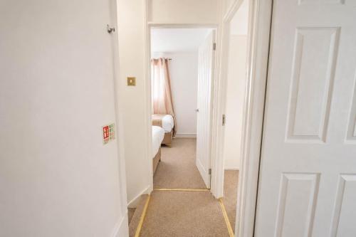 a hallway with a white door and a bedroom at Hill's View - 6 Sleeps - 10 minute walk to the town in Barnstaple