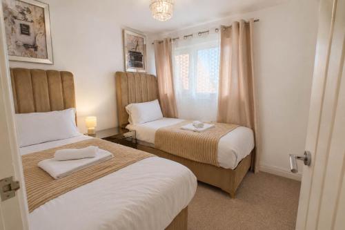 a small room with two beds and a window at Hill's View - 6 Sleeps - 10 minute walk to the town in Barnstaple