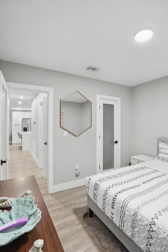 a white bedroom with a bed and a mirror at Mango Tree House in Hialeah