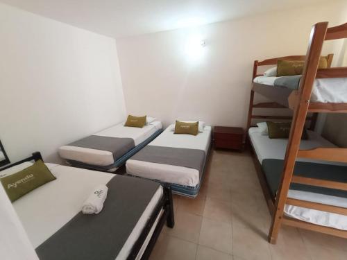 a room with four bunk beds and a ladder at Hotel Charmin in Gaira