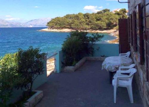 a patio with a table and chairs and the ocean at Apartments Sova By the Sea in Postira