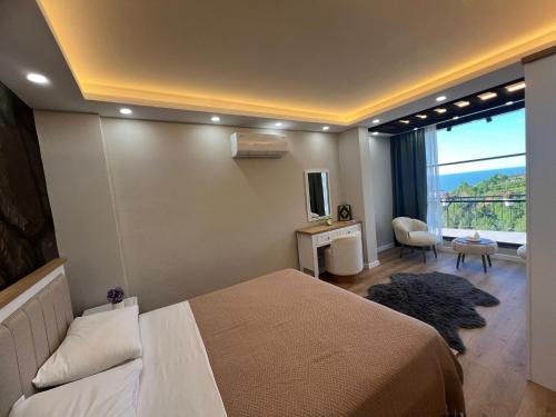 a bedroom with a bed and a large window at cam teraslı köyevi in Cayeli
