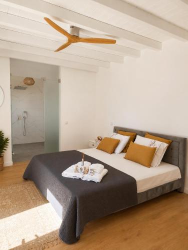 a bedroom with a large bed with a ceiling fan at Recanto D Idjaro in Recanto