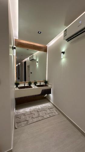 a bathroom with two sinks and a large mirror at شاليه وقاعة ايليت in Buraydah