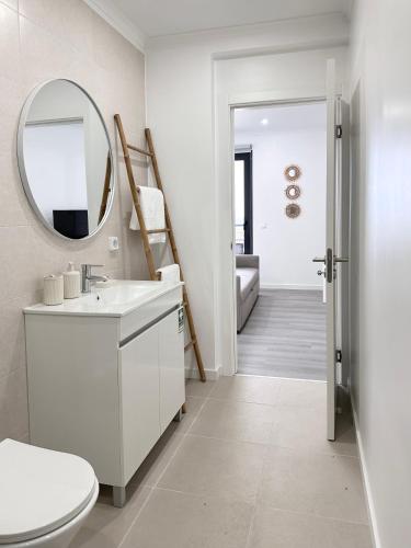 a white bathroom with a sink and a mirror at Waves Madeira I in Caniçal
