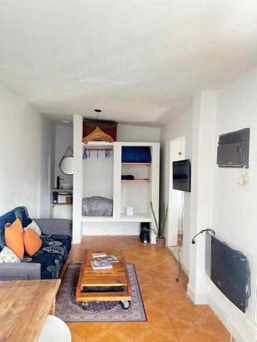 a living room with a couch and a table at Casa Milos para dos personas frente al rio in Santa Rosa de Calamuchita