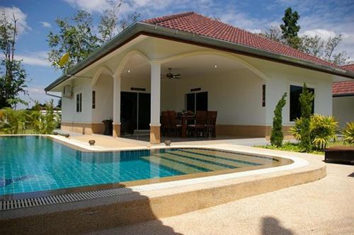 a house with a swimming pool in front of a house at Little Paradise in Ban Phe
