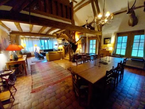 a large living room with a table and chairs at Les Gordons in Chaumont-sur-Tharonne