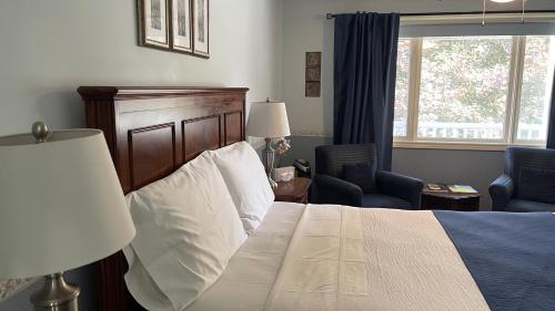 a bedroom with a bed and a chair and a window at Bruce Manor in Niagara-on-the-Lake