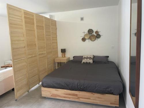 a bedroom with a bed and a large wooden wall at Soleya Apartment in Quartier de Lorient