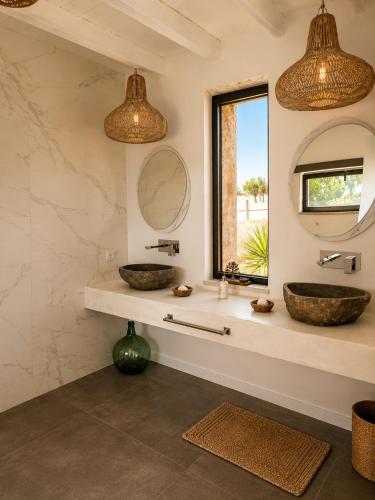 a bathroom with two sinks and two mirrors at Recanto D Idjaro in Recanto
