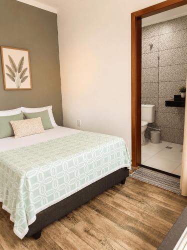 a bedroom with a bed and a bathroom with a shower at Casa com Vista inigualável "Vista del Lago" in Capitólio
