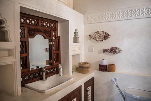 a bathroom with a sink and a mirror at Lamu Treasures Shela Kenya in Shela