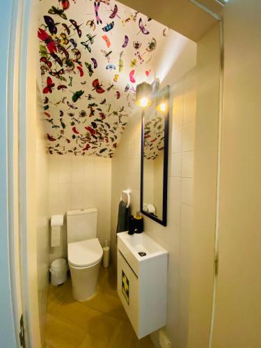 a bathroom with a toilet and butterflies on the ceiling at Senhora da Rocha Sea View, Pool, Terrace in Porches