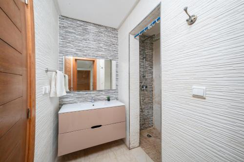 a white bathroom with a sink and a shower at Waterfront apartment in Imiouadar in Agadir nʼ Aït Sa