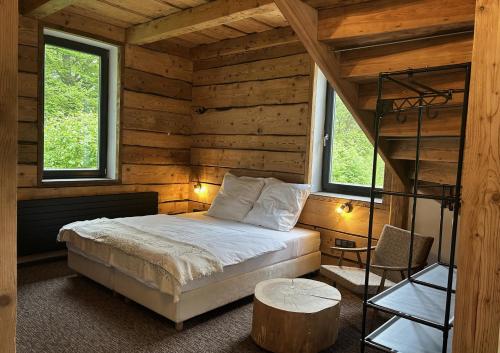 a bedroom with a bed in a log cabin at Lesní Mlýn Depandance in Mariánské Lázně