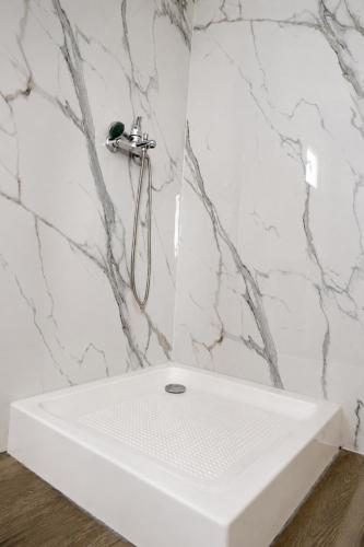 a white sink in a bathroom with marble walls at NIBIRU OFFICIAL ACCOMMODATION LUNR Camp in Costinesti