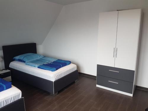 1 Schlafzimmer mit 2 Betten, einer Kommode und einem Spiegel in der Unterkunft Hotel Restaurant Kroatia in Dortmund