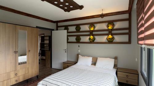 a bedroom with a white bed and a mirror at cam teras villa in Cayeli