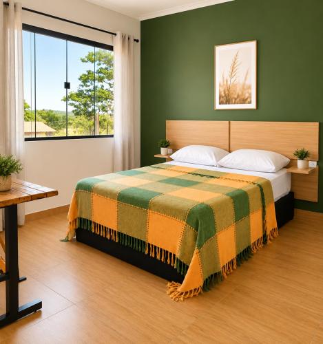 a bedroom with a bed and a large window at Casa com Jacuzzi Charme Corumbá in Alexânia