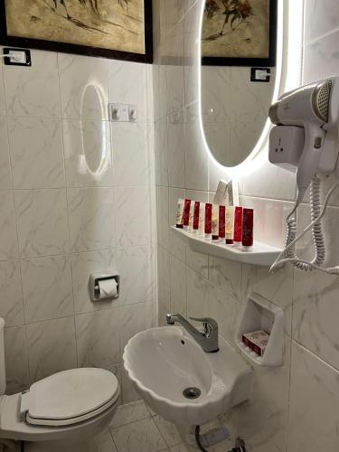 a bathroom with a sink and a toilet and a mirror at SEACODE Hotel in El Alamein