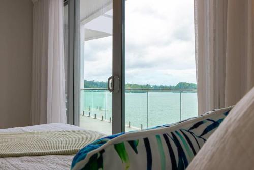 a bedroom with a window with a view of the water at 403 - Suva City Views Oceanfront Large Balcony in Suva