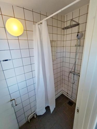 a bathroom with a shower with a white shower curtain at Double room 1 with Free Parking in Nørresundby