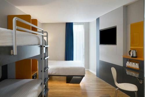 a room with two bunk beds and a tv at Four Points Flex by Sheraton Cardiff in Cardiff