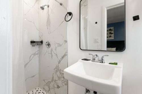 a white bathroom with a sink and a mirror at Encore Inn Inglewood in Inglewood