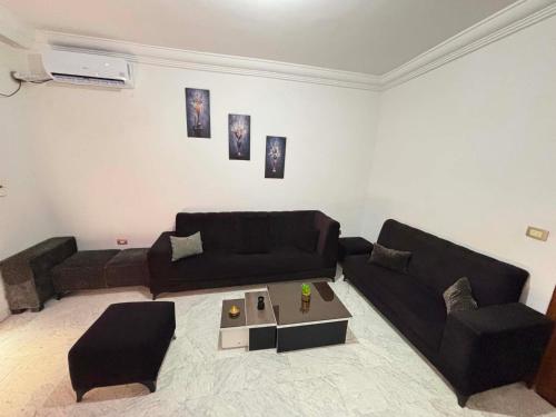 a living room with a black couch and a table at Le bienvenu in Sousse