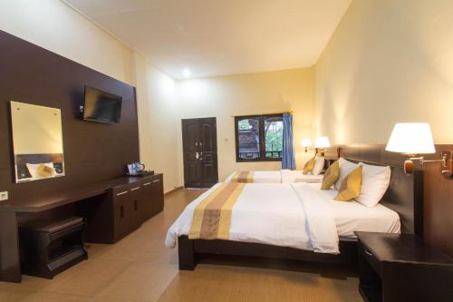 a bedroom with a large bed and a desk at Bali Sandy Resort in Kuta