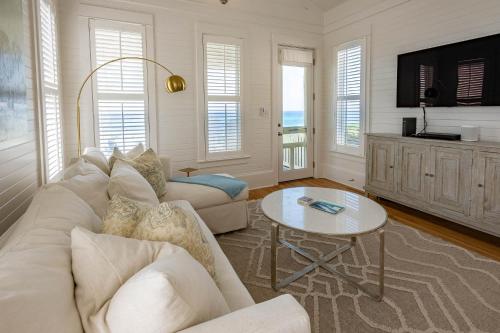 a living room with a white couch and a table at Magnolia Honeymoon Cottage in Santa Rosa Beach