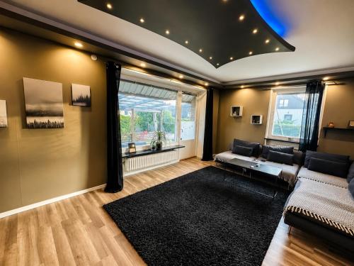 a living room with a couch and a large window at Lägenhet med trädgård på Österlen, nära hav & golf in Gärsnäs