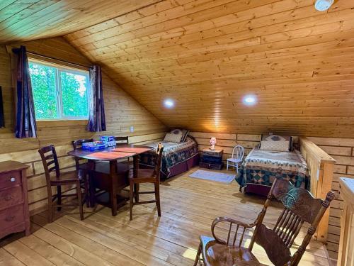 a room with two beds and a table in a cabin at Riverfront, Authentic, Luxury Log Cabin-Gray Wolf in Wasilla