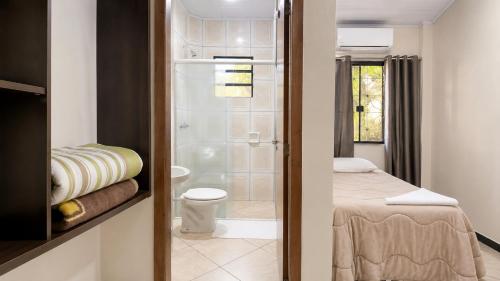 a small bathroom with a toilet and a shower at hotel Maanaim in Candói