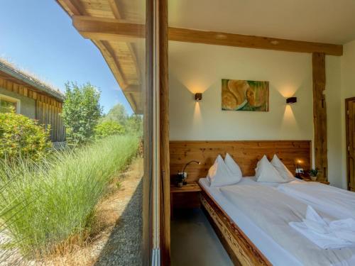 a bedroom with a bed with a view of a field at See Chalet 50 in Lake Pressegg