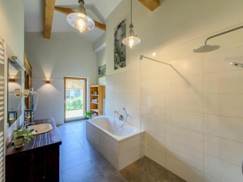 a bathroom with a tub and a shower and a sink at Oselitzen 56 in Lake Pressegg