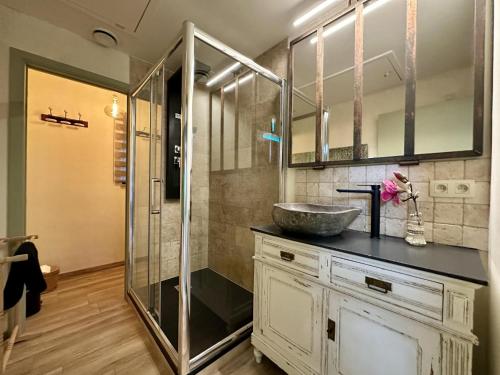 a bathroom with a sink and a glass shower at Léoras Cocoon in Membre