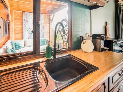 a kitchen with a sink and a window with a couch at Zomerzoet in Brouwershaven