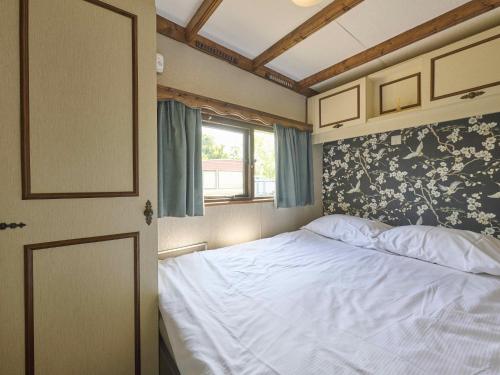 a bedroom with a white bed and a window at Zomerzoet in Brouwershaven