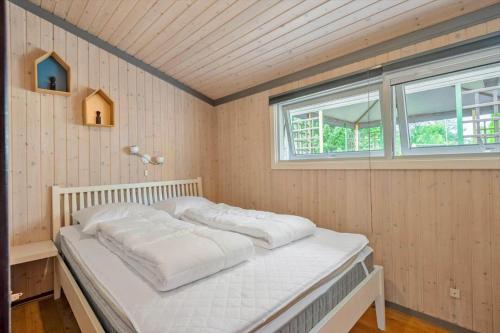 a white bed in a room with a window at 8159-Praesto-Vagtelvej-8 in Præstø