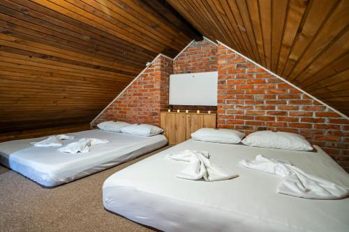 two beds in a room with a brick wall at Odmaraliste Paradise14 - Private Villa with Heated Pool & Jacuzzi in Rainci Gornji