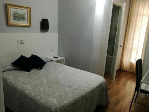 Ένα ή περισσότερα κρεβάτια σε δωμάτιο στο Hostal Lesseps